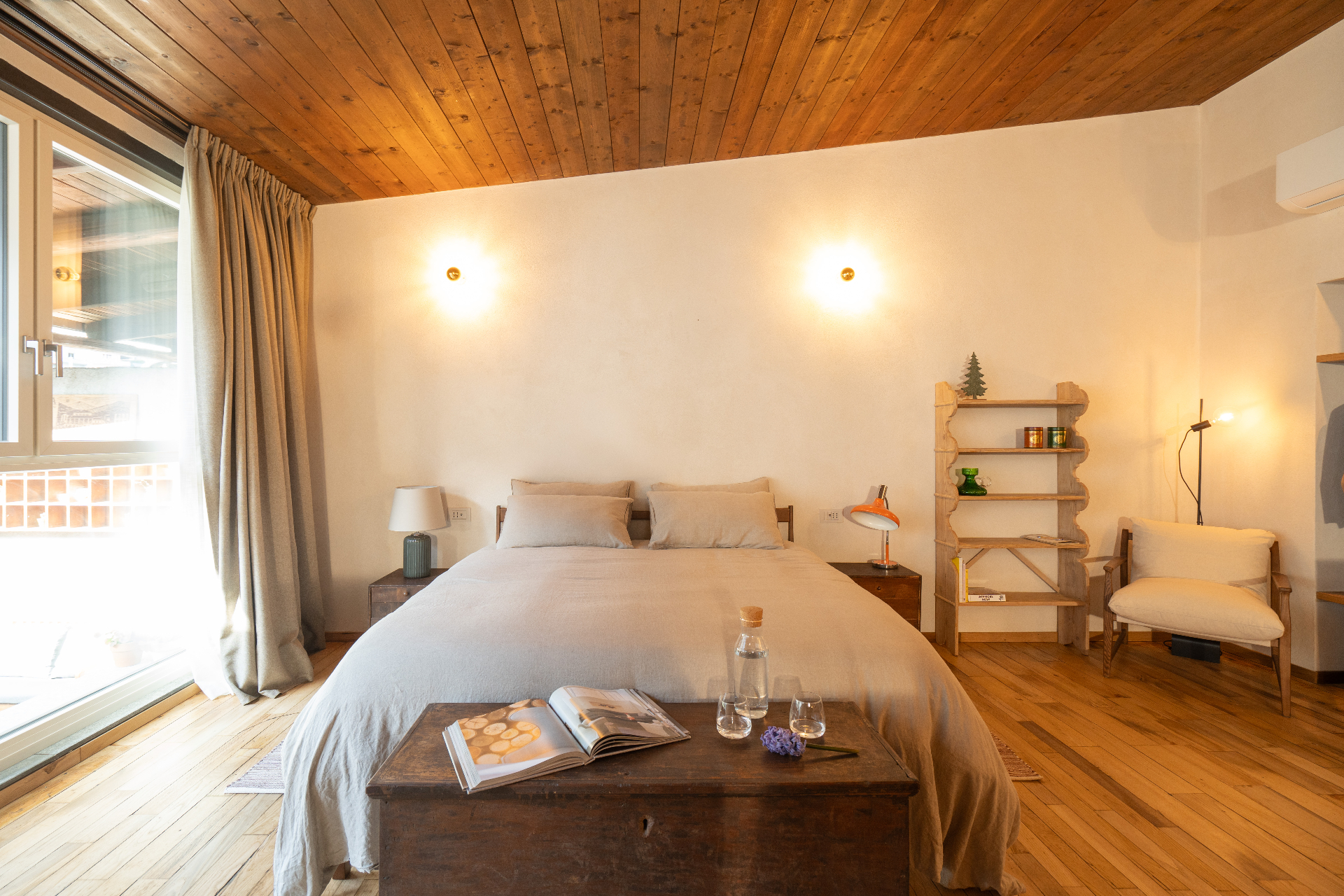 Le Dimore — camera da letto con soffitto in legno e luce naturale